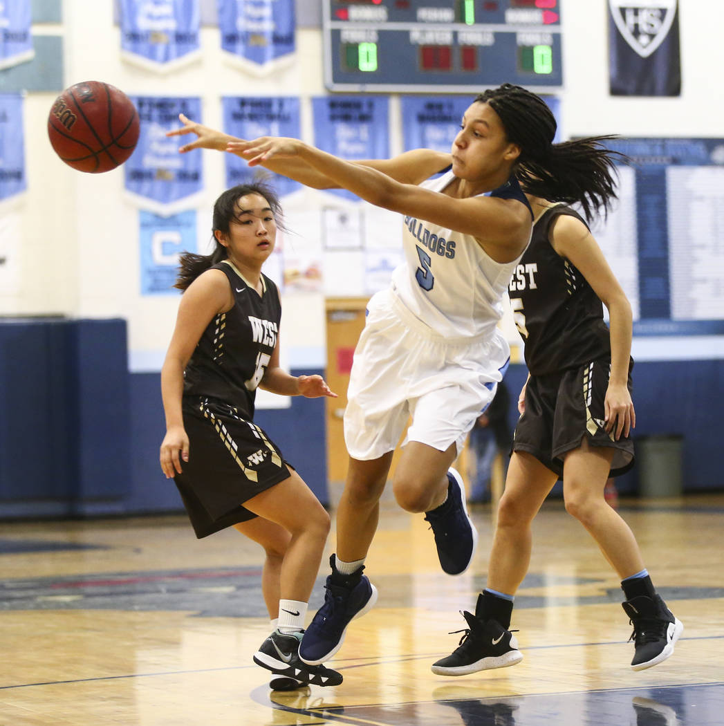 Centennial’s Jade Thomas (5) throws the ball past West’s Rachel Arakawa (15) during a basketball game at Centennial High School in Las Vegas on Saturday, Dec. 29, 2018. Chase Stevens ...