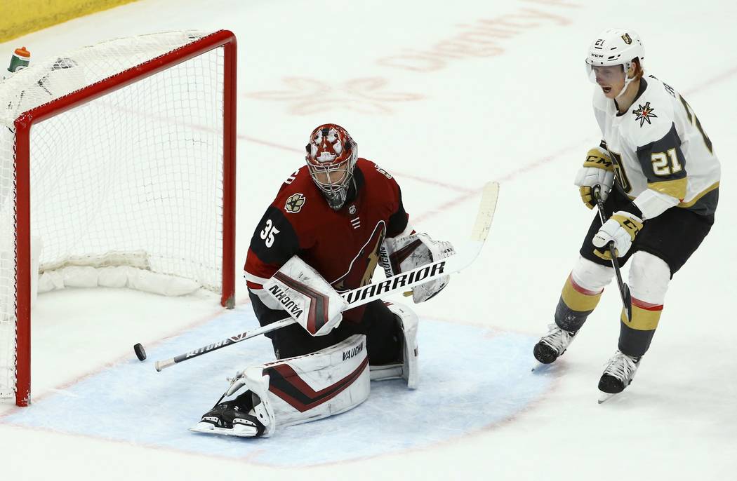 Arizona Coyotes goaltender Darcy Kuemper (35) gives up a goal to Vegas Golden Knights Ryan Carpenter as Golden Knights center Cody Eakin (21) looks on during the third period of an NHL hockey game ...