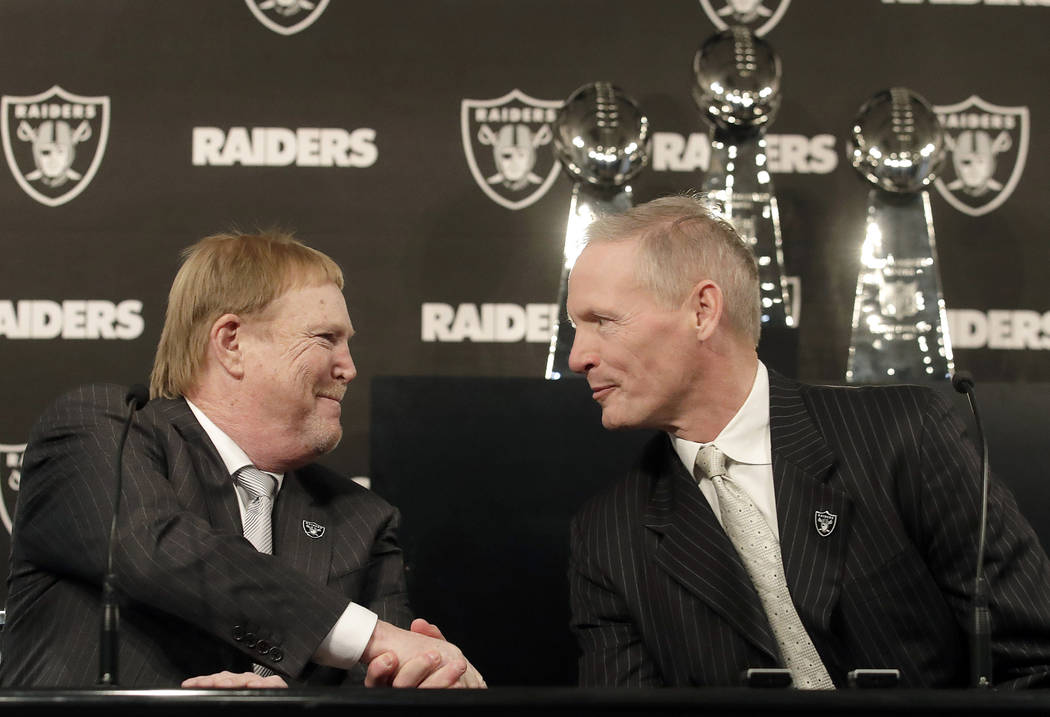 Mike Mayock, right, shakes hands with Oakland Raiders owner Mark Davis at a news conference announcing Mayock as the team's general manager in Oakland, Calif., Monday, Dec. 31, 2018. (AP Photo/Jef ...