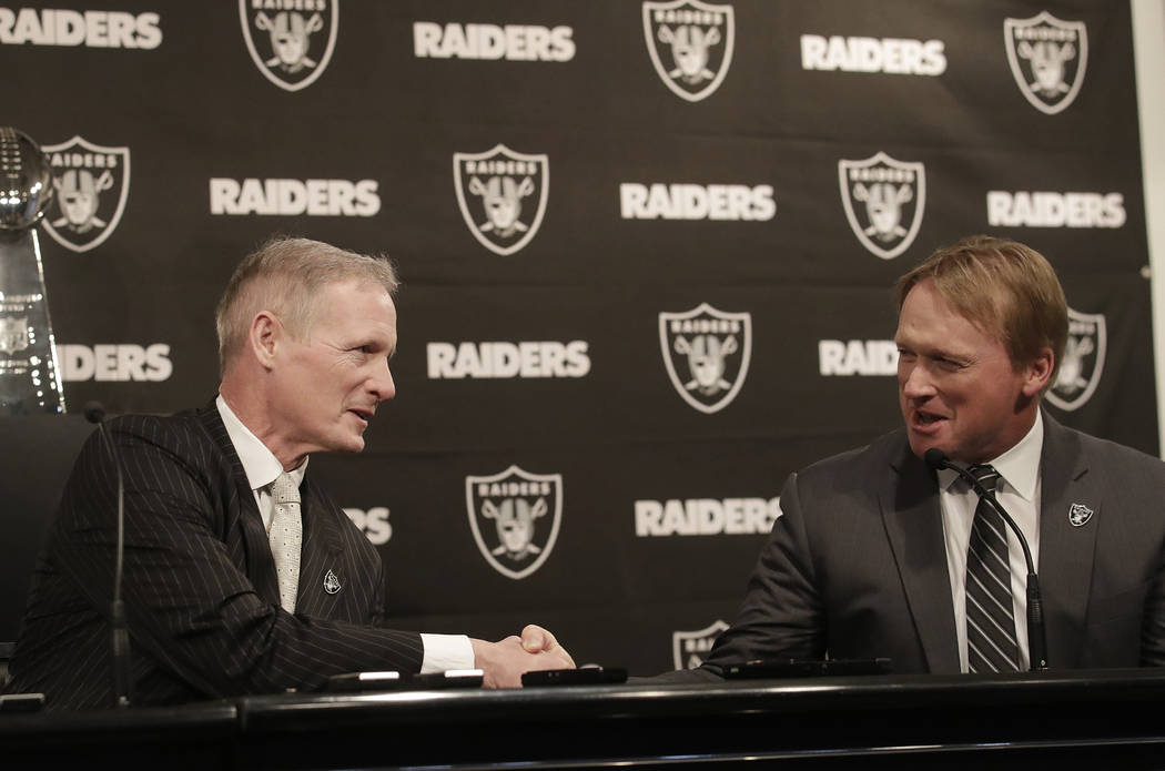 Mike Mayock, left, shakes hands with Oakland Raiders head coach Jon Gruden at a news conference announcing Mayock as the team's general manager in Oakland, Calif., Monday, Dec. 31, 2018. (AP Photo ...
