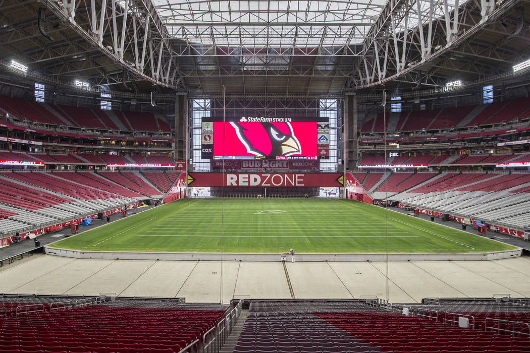 Engineer Don Kramer, middle, oversees the installation of the grass field tray system in preparation for the Phoenix Cardinals NFL football game at State Farm Stadium on Friday, Dec. 21, 2018, in ...