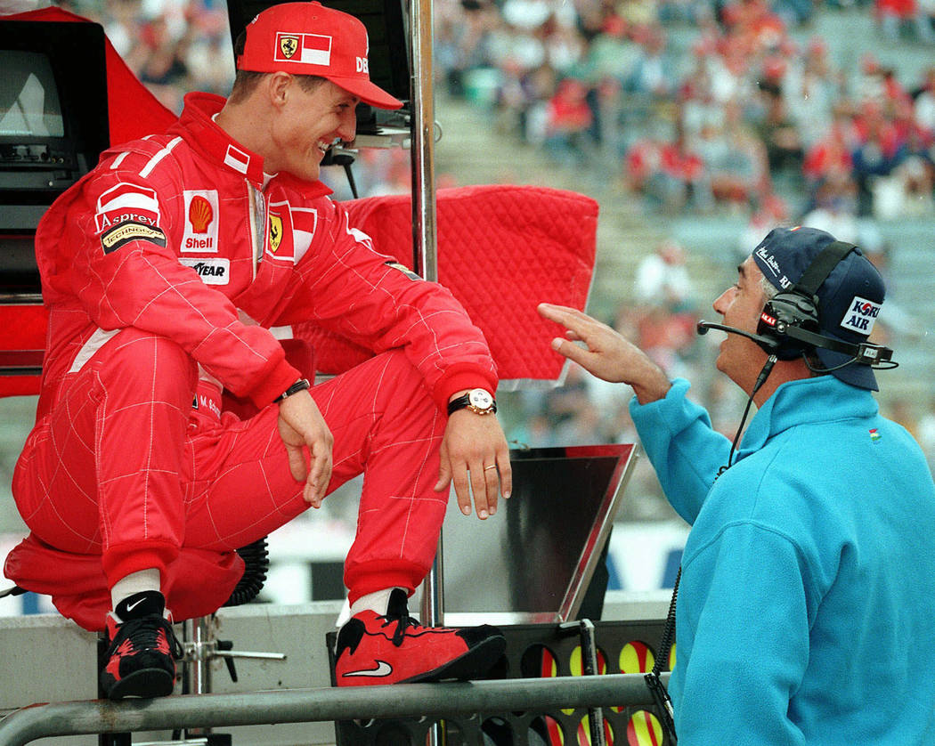 In this July 25, 1997, file photo, Germany's Michael Schumacher, left, of the Ferrari team, shares a joke with Benetton chief Flavio Briatore, right, at the start of the first free practice sessio ...