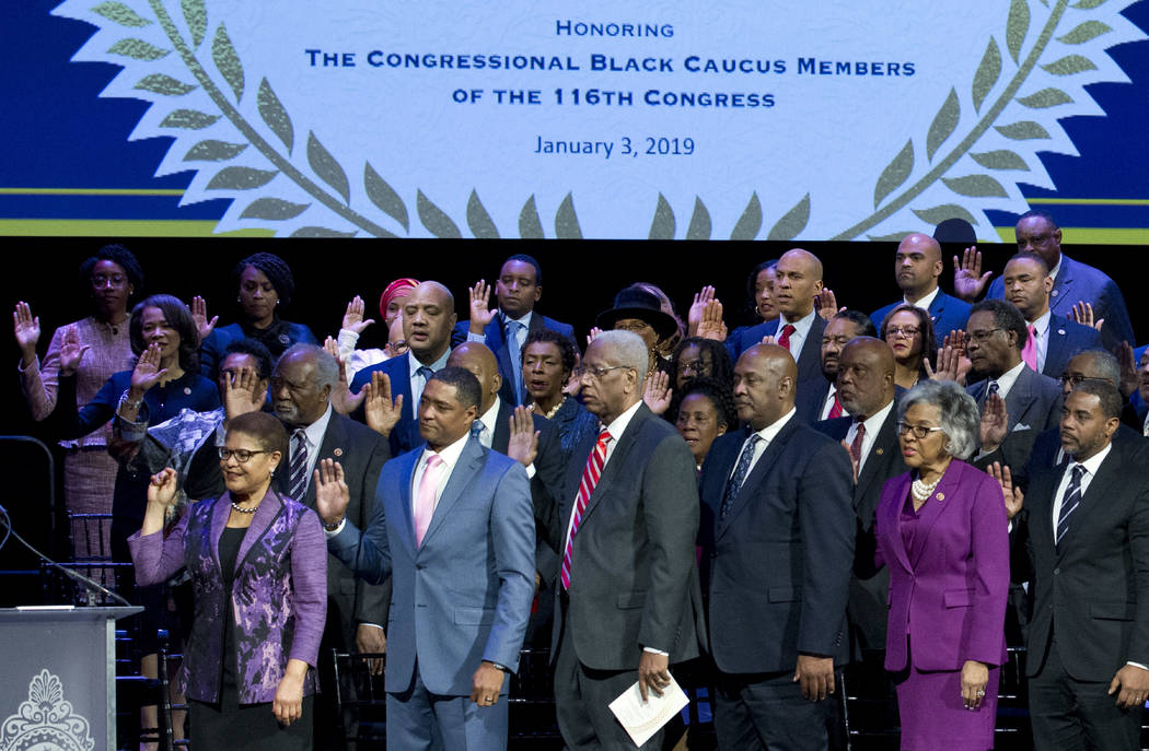 Members of the Congressional Black Caucus raise their hands during the swearing-in ceremony of CBC members at The Warner Theatre in Washington, Thursday, Jan. 3, 2019. (AP Photo/Jose Luis Magana)