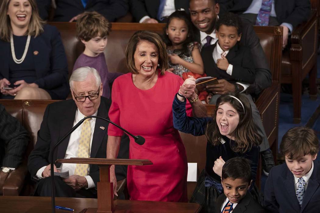 With some enthusiastic assistance from her grandchildren, House Democratic Leader Nancy Pelosi of California smiles as she casts her vote for herself to be speaker of the House on the first day of ...