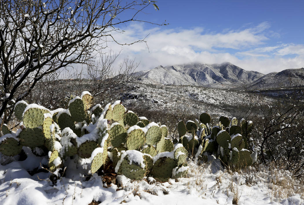 The Empire Mountains emerge from cloud cover after the second round of winter storms brought snowfall to the surrounding metro Tucson area and southeast Arizona, Jan. 2, 2019, south of Vail, Ariz. ...