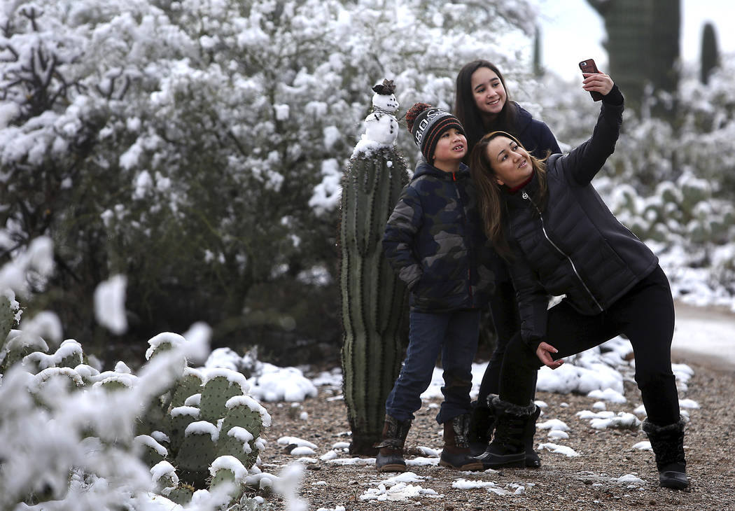 "It's the first time we've seen snow the desert," says Mayra Vasquez who brought Valeria Luzania, 11, and MarcoDario Luzania, 8, to Saguaro National Park East on January 02, 2019. The ki ...
