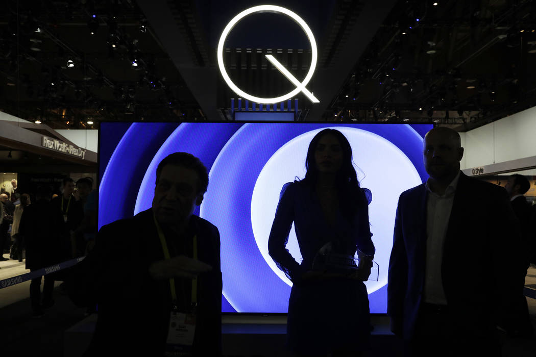 Attendees stand in front of a QLED TV at the Samsung booth during CES International in Las Vegas on Jan. 6, 2017. Critics have been on the case of one of the tech industry’s largest trade shows ...