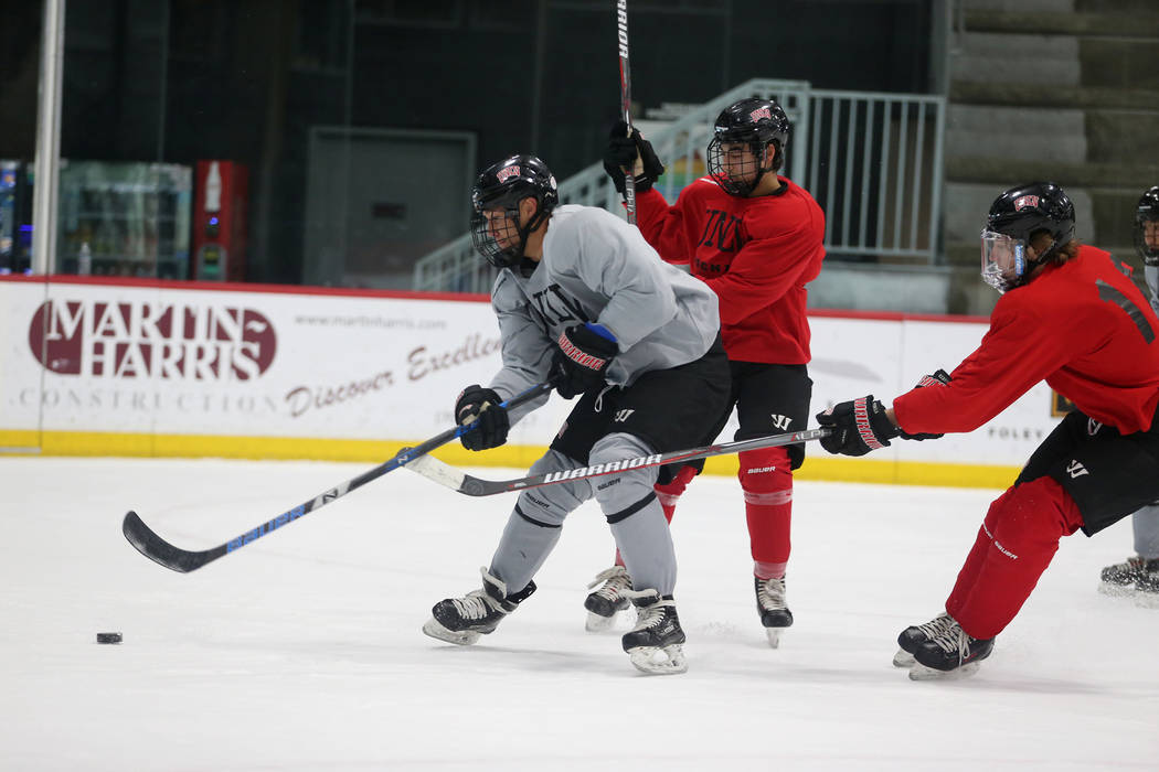 Jared Turcotte, from left, looks for a shot under pressure from Jordan Rea, and Tommy Harrison during an UNLV hockey team practice at City National Arena in Las Vegas, Friday, Jan. 4, 2019. Erik V ...