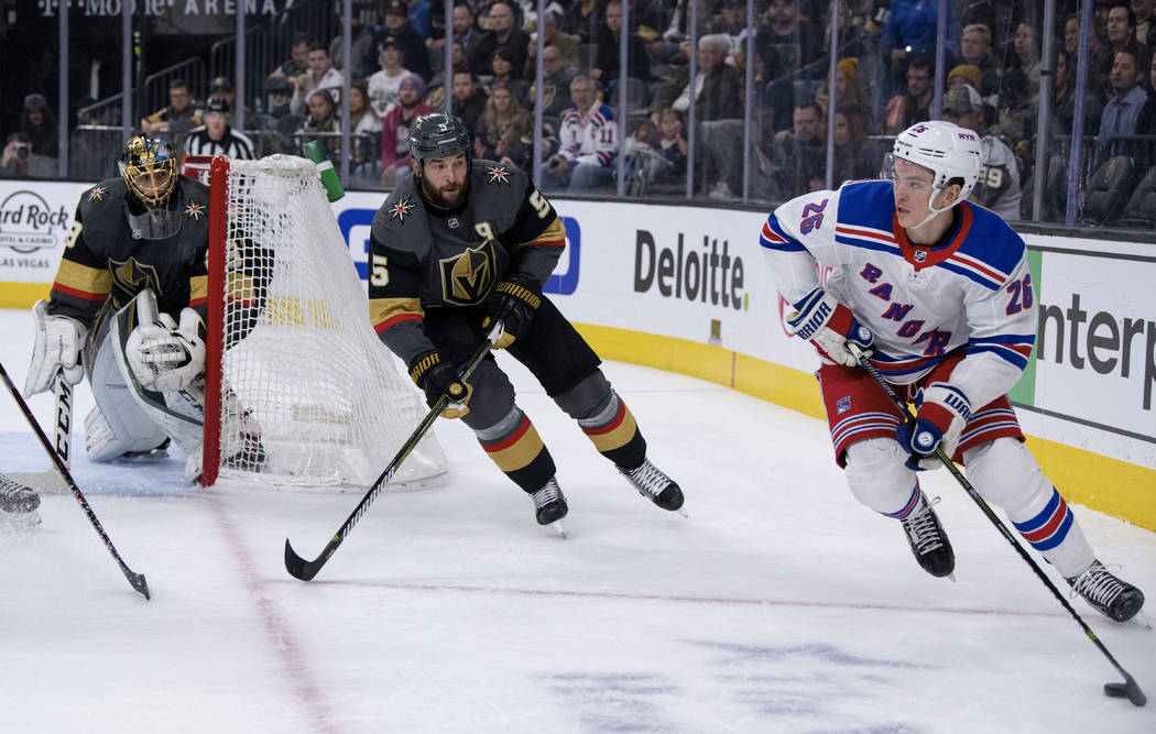 New York Rangers left wing Jimmy Vesey looks for a pass while being defended by Vegas Golden Knights defenseman Deryk Engelland during the first period of an NHL hockey game Tuesday, Jan. 8, 2019, ...