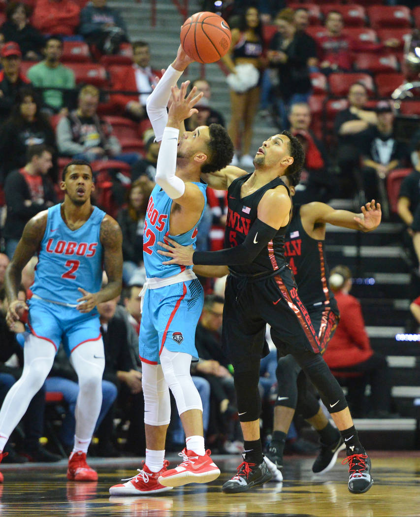 UNLV Rebels guard Noah Robotham (5) tips the ball away from New Mexico Lobos guard Anthony Mathis (32) during the first half of the UNLV Rebels and the New Mexico Lobos NCAA basketball game at the ...