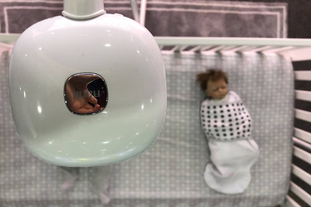 A monitor from Nanit that keeps track of babies' breathing rate hovers over dolls on Tuesday, January 8 at CES 2019. The breathing wear will be on the market in the U.S. and Canada in March. (Bail ...