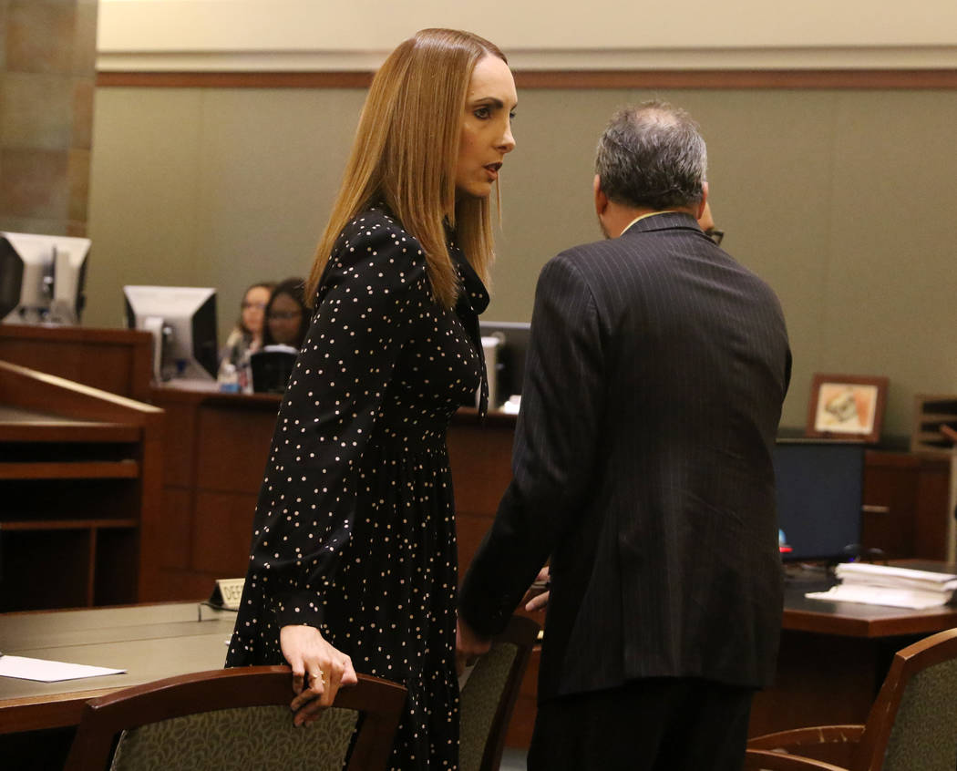 Attorney Alexis Plunkett, left, who prosecutors say bragged about putting a hit on her former boyfriend in prison, takes a seat during her court hearing at the Regional Justice Court in Las Vegas, ...