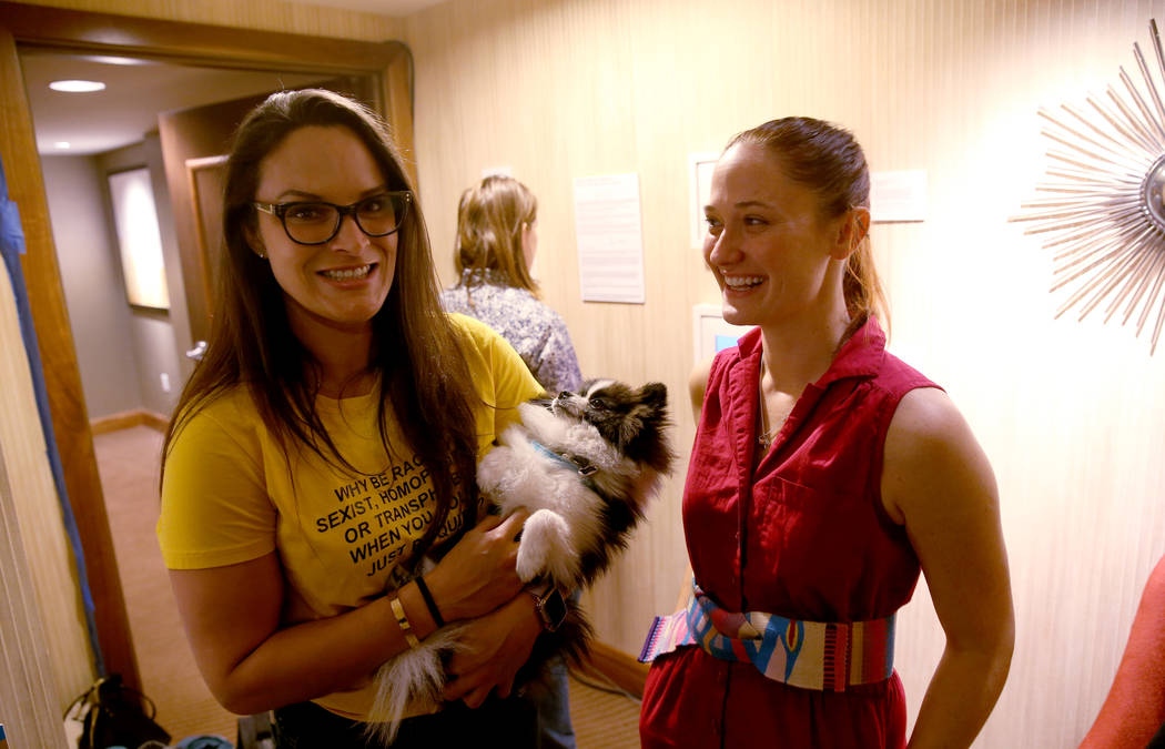 Lora Haddock, with her dog Enzo, founder of tech startup Lora DiCarlo, left, and Director of Marketing Sarah Brown mingle during the Hardware Massive CES 2019 Happy Hour Bash at The Hangover Suite ...