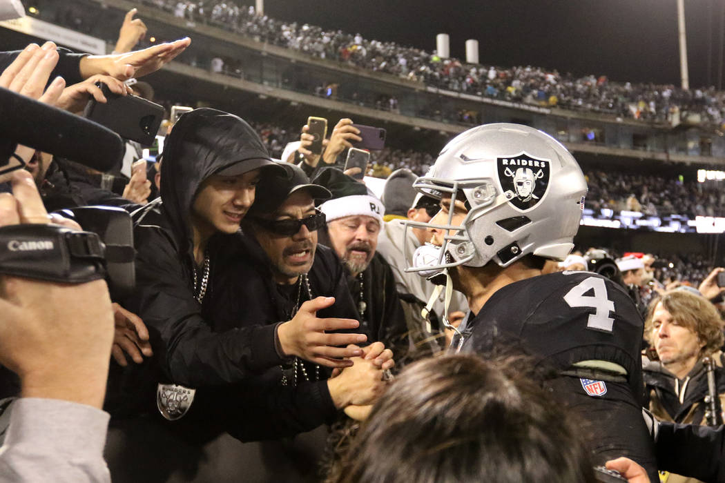 Oakland Raiders quarterback Derek Carr (4) meets with fans in the Black Hole in the Oakland-Alameda County Coliseum field after the team's win over the against the Denver Broncos in Oakland, Calif ...