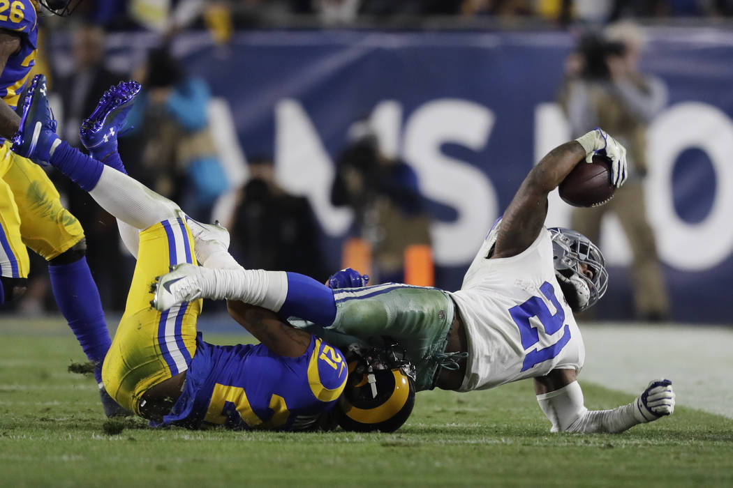 Dallas Cowboys running back Ezekiel Elliott is tackled by Los Angeles Rams cornerback Aqib Talib during the first half in an NFL divisional football playoff game Saturday, Jan. 12, 2019, in Los An ...