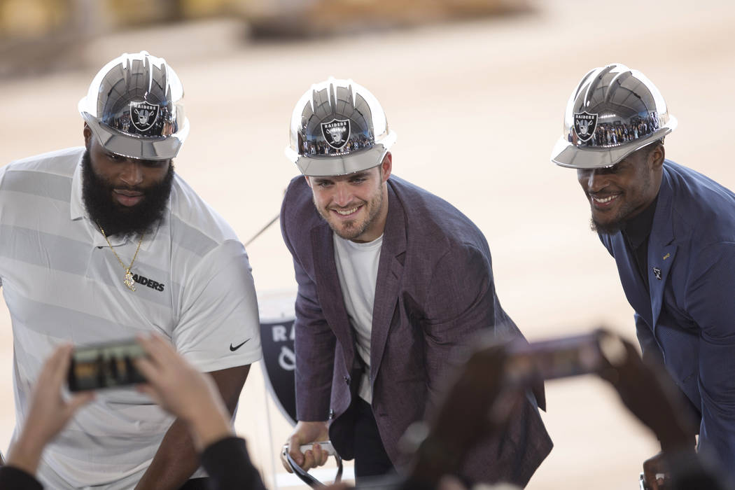 Raiders quarterback Derek Carr is flanked by teammates Justin Ellis, left, and Tahir Whitehead during a groundbreaking ceremony for the new Raiders Headquarters in Henderson on Monday, Jan. 14, 20 ...