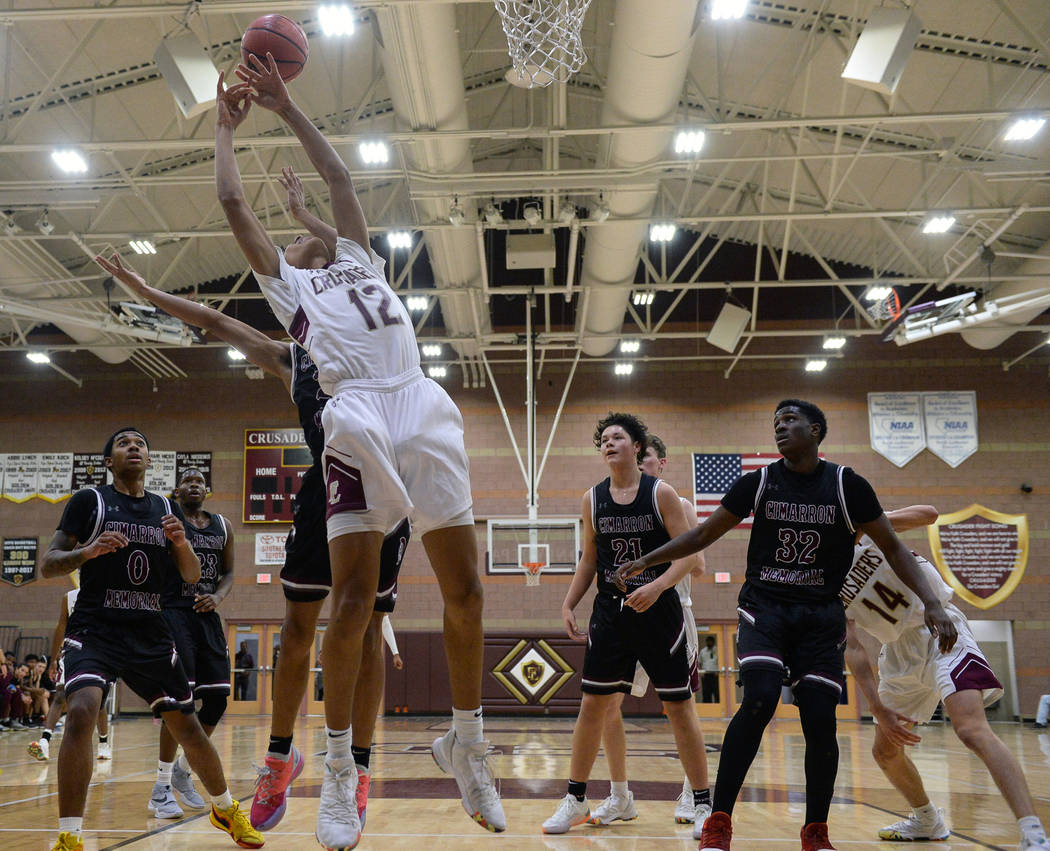 Faith Lutheran's Jackson Williams (12) reaches for the ball while under pressure from Cimarron Memorial's Kevin Johnson (30) during the second half of a basketball game at Faith Lutheran High Scho ...