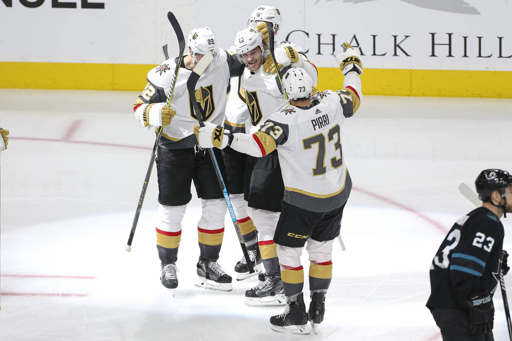 Vegas Golden Knights defenseman Jon Merrill (15), center, is swarmed by teammates after scoring against the San Jose Sharks during the third period of an NHL hockey game at T-Mobile Arena in Las V ...