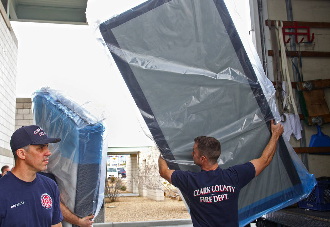 Firefighter Kevin Foreman, left, and Engineer Phil Robichaud unload mattresses at Fire Station 22 in Las Vegas, Wednesday, Jan. 16, 2019. Walker Furniture delivered new mattresses to all 30 Clark ...