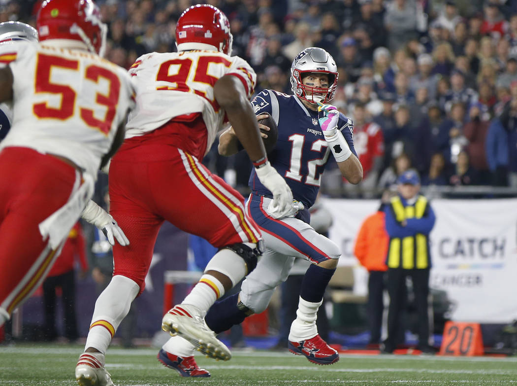 New England Patriots quarterback Tom Brady (12) runs past Kansas City Chiefs linebacker Anthony Hitchens (53) and defensive tackle Chris Jones (95) for a touchdown during the second half of an NFL ...