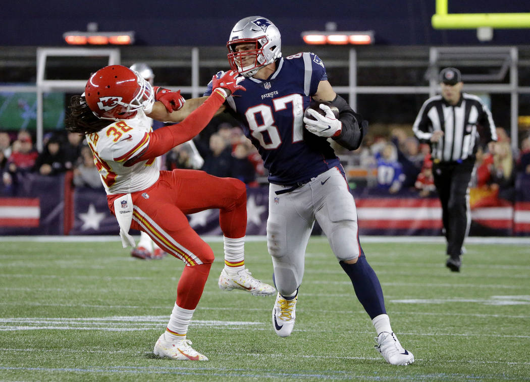 New England Patriots tight end Rob Gronkowski (87) gives a stiff arm to Kansas City Chiefs free safety Ron Parker (38) after catching a pass during the second half of an NFL football game, Sunday, ...