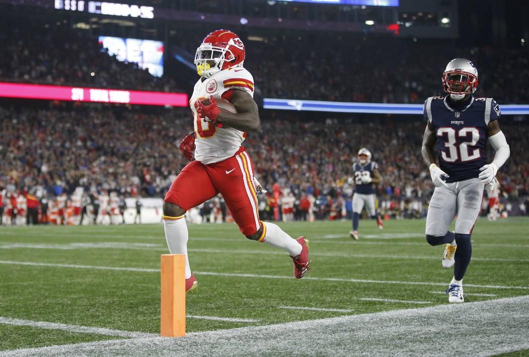 Kansas City Chiefs wide receiver Tyreek Hill (10) scores a touchdown in front of New England Patriots defensive back Devin McCourty (32) after catching a pass during the second half of an NFL foot ...
