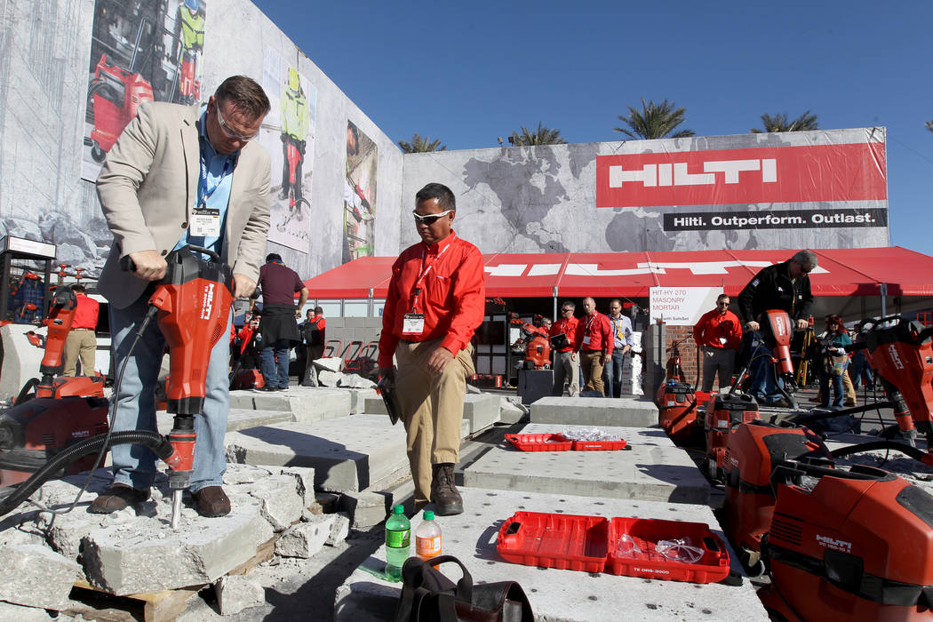Mathew Burns of Jupiter, Fla., left, checks out a jackhammer with Hilti representative Paul Adajar during the World of Concrete show at the Las Vegas Convention Center Tuesday, Jan. 23, 2018. K.M. ...