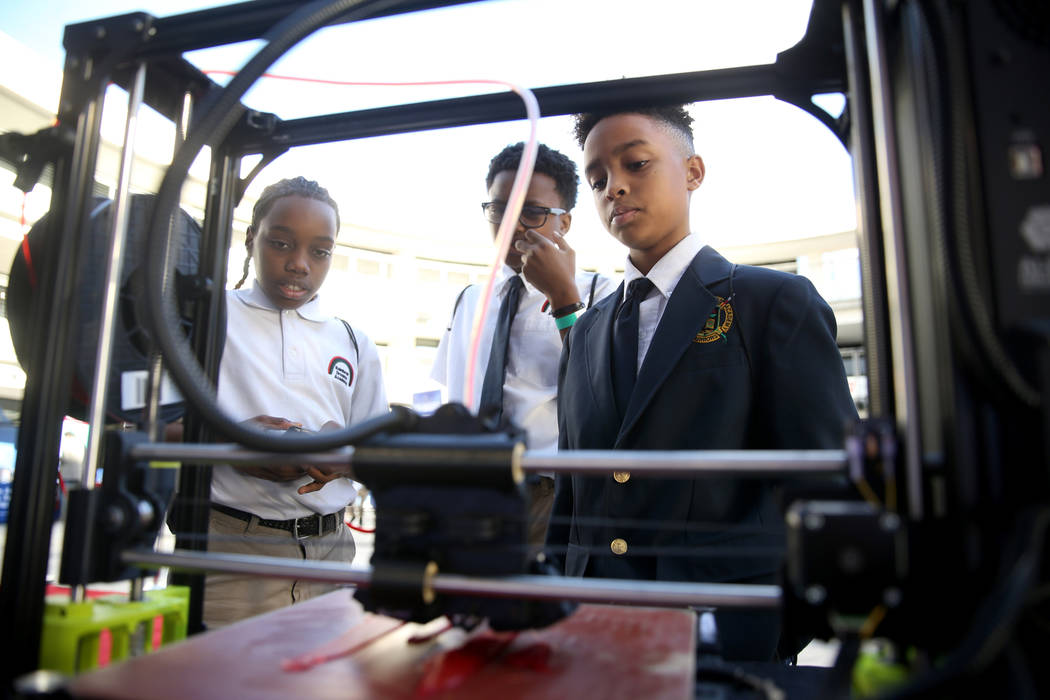 Rainbow Dreams Academy sixth-graders, from left, Marcel Elzy, 11, Wayne Harper, 12, and Nehemiah Mayfield, 11, check out a 3D printer during the the first Dr. Martin Luther King Jr. Technology Sum ...