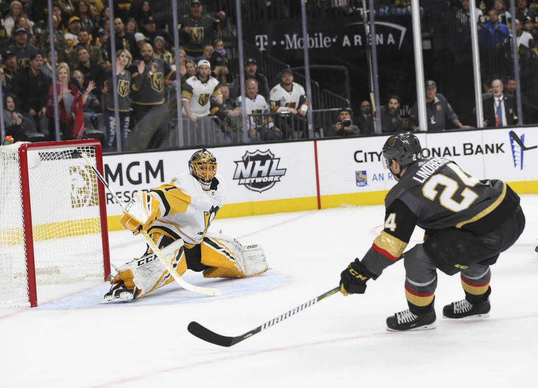 Golden Knights center Oscar Lindberg (24) gets the puck past Pittsburgh Penguins goaltender Casey DeSmith (1) to score a goal during the first period of an NHL hockey game at T-Mobile Arena in Las ...