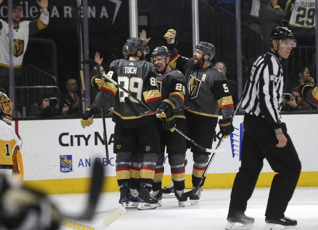 Golden Knights right wing Alex Tuch (89), center Paul Stastny (26) and defenseman Deryk Engelland (5) celebrate a goal by left wing Max Pacioretty, not pictured, during the first period of an NHL ...