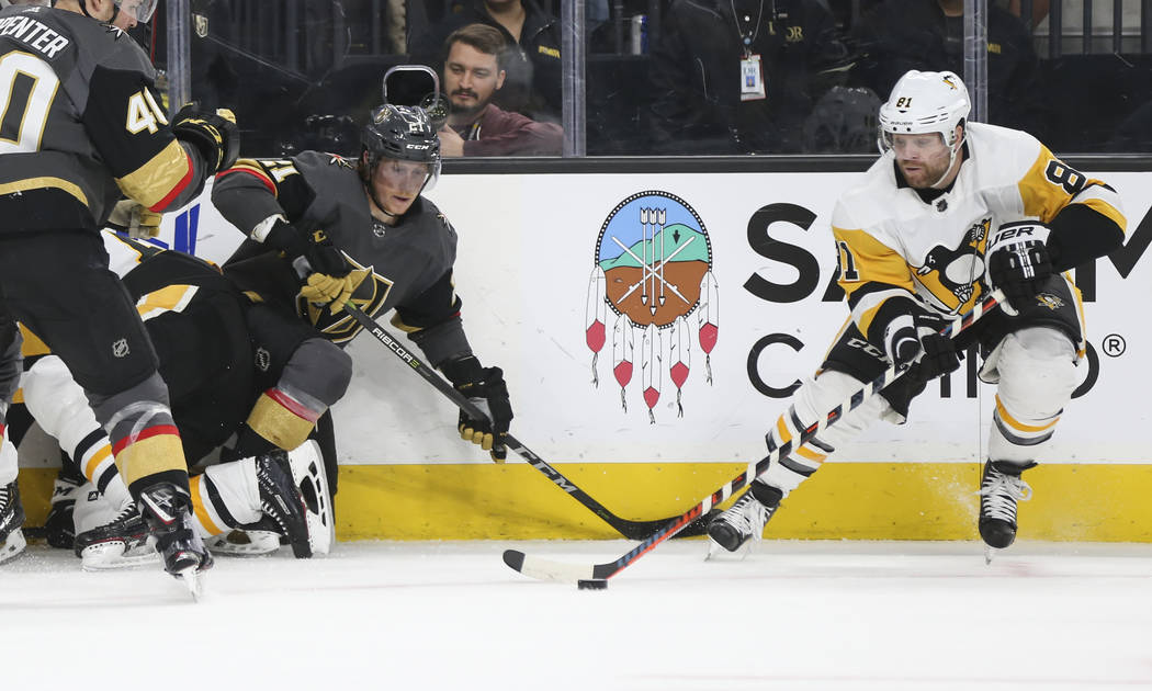 Pittsburgh Penguins right wing Phil Kessel (81) moves the puck past Golden Knights center Cody Eakin (21) during the first period of an NHL hockey game at T-Mobile Arena in Las Vegas on Saturday, ...