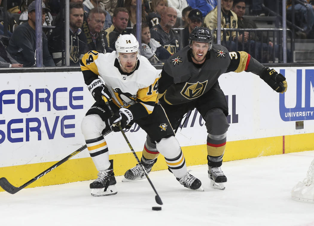 Pittsburgh Penguins left wing Tanner Pearson (14) moves the puck in front of Golden Knights defenseman Brayden McNabb (3) during the second period of an NHL hockey game at T-Mobile Arena in Las Ve ...