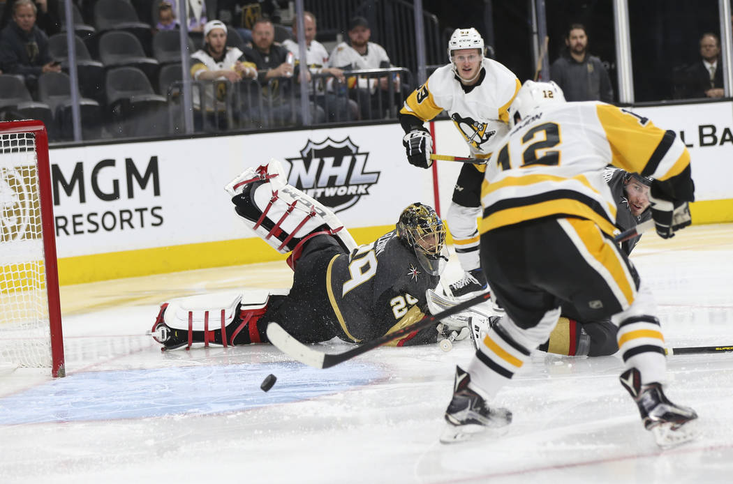 Pittsburgh Penguins center Dominik Simon (12) sends the puck into the net past Golden Knights goaltender Marc-Andre Fleury (29) during the second period of an NHL hockey game at T-Mobile Arena in ...