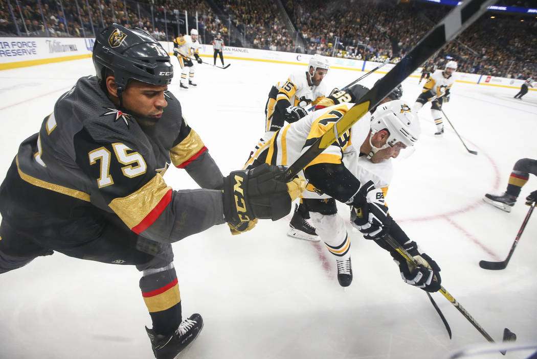 Golden Knights right wing Ryan Reaves (75) and Pittsburgh Penguins defenseman Jack Johnson (73) battle for the puck during the first period of an NHL hockey game at T-Mobile Arena in Las Vegas on ...