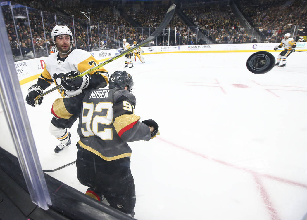 Pittsburgh Penguins center Matt Cullen (7) sends the puck past Golden Knights left wing Tomas Nosek (92) during the third period of an NHL hockey game at T-Mobile Arena in Las Vegas on Saturday, J ...