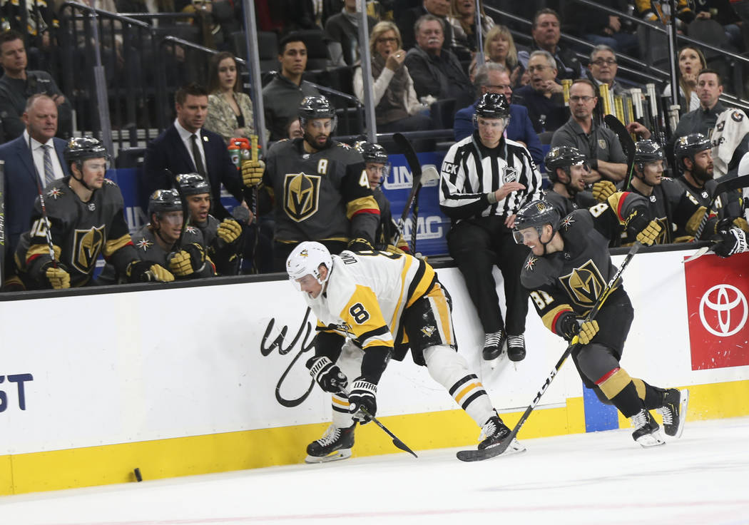 Golden Knights center Jonathan Marchessault (81) chases after the puck next to Pittsburgh Penguins defenseman Brian Dumoulin (8) during the third period of an NHL hockey game at T-Mobile Arena in ...