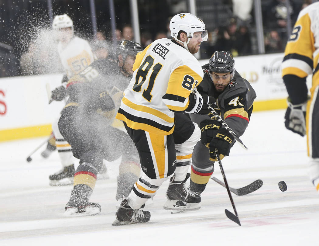 Golden Knights center Pierre-Edouard Bellemare (41) sends the puck past Pittsburgh Penguins right wing Phil Kessel (81) during the third period of an NHL hockey game at T-Mobile Arena in Las Vegas ...