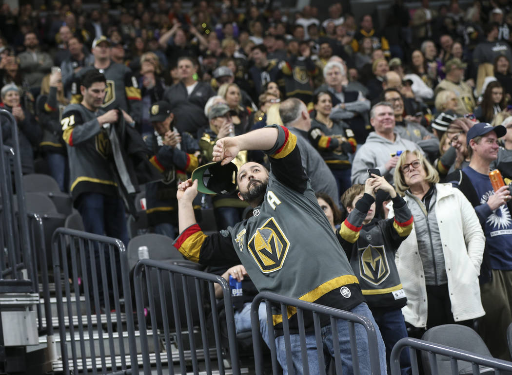 Golden Knights fans throw their hats onto the ice in celebration of a hat trick by Jonathan Marchessault, not pictured, during the third period of an NHL hockey game against the Pittsburgh Penguin ...
