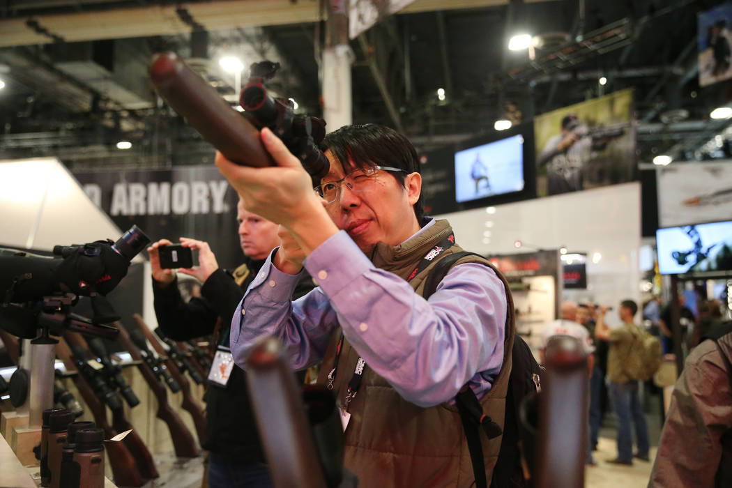 Randy Wei of Taiwan checks out a scope during the SHOT Show at the Sands Expo Convention Center in Las Vegas, Tuesday, Jan. 22, 2019. Erik Verduzco/Las Vegas Review-Journal) @Erik_Verduzco