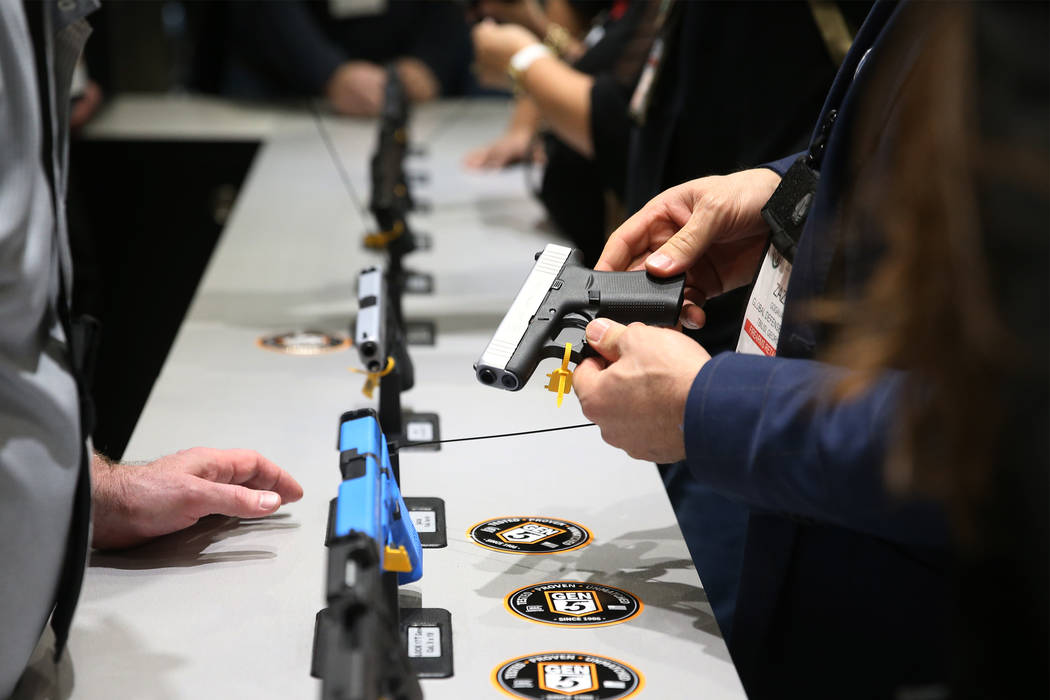 A person checks out a handgun during the SHOT Show at the Sands Expo Convention Center in Las Vegas, Tuesday, Jan. 22, 2019. Erik Verduzco/Las Vegas Review-Journal) @Erik_Verduzco