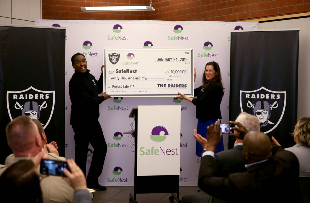 Raiders alumnus Leo Gray presents SafeNest CEO Liz Ortenburger with a check at SafeNest headquarters in Las Vegas on Thursday, Jan. 24, 2019. The money will help fund Project Safe 417, a partnersh ...