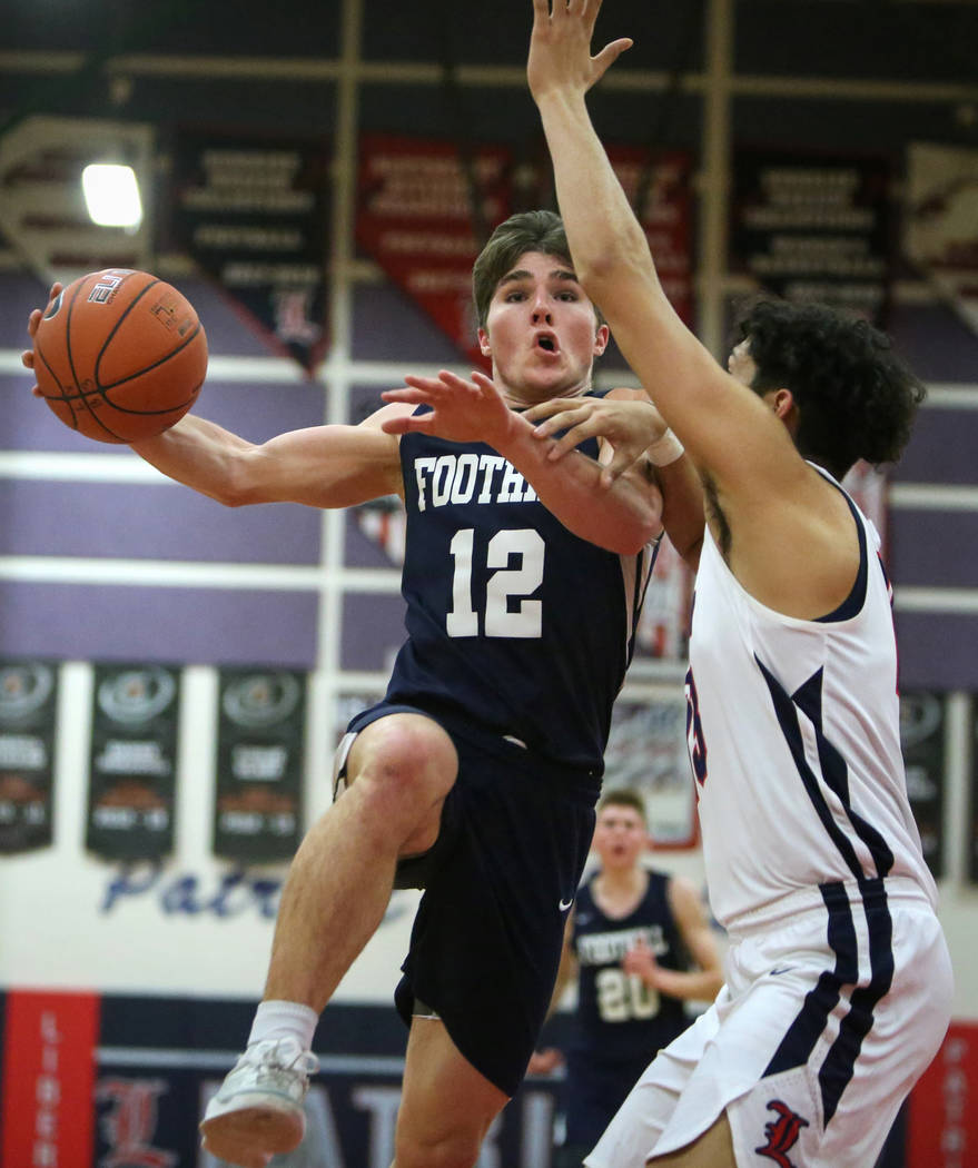 Foothill's Fisher Welch (12) drives to the net while under pressure from Liberty's Terrance Marigney (13) during a basketball game at Liberty High School in Las Vegas, Wednesday, Jan. 23, 2019. Ca ...