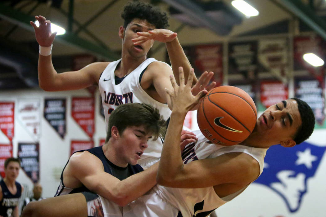 Liberty's Kobe Stroughter (1) falls with the ball while being guarded by Foothill's Fisher Welch (12) during a basketball game at Liberty High School in Las Vegas, Wednesday, Jan. 23, 2019. Caroli ...