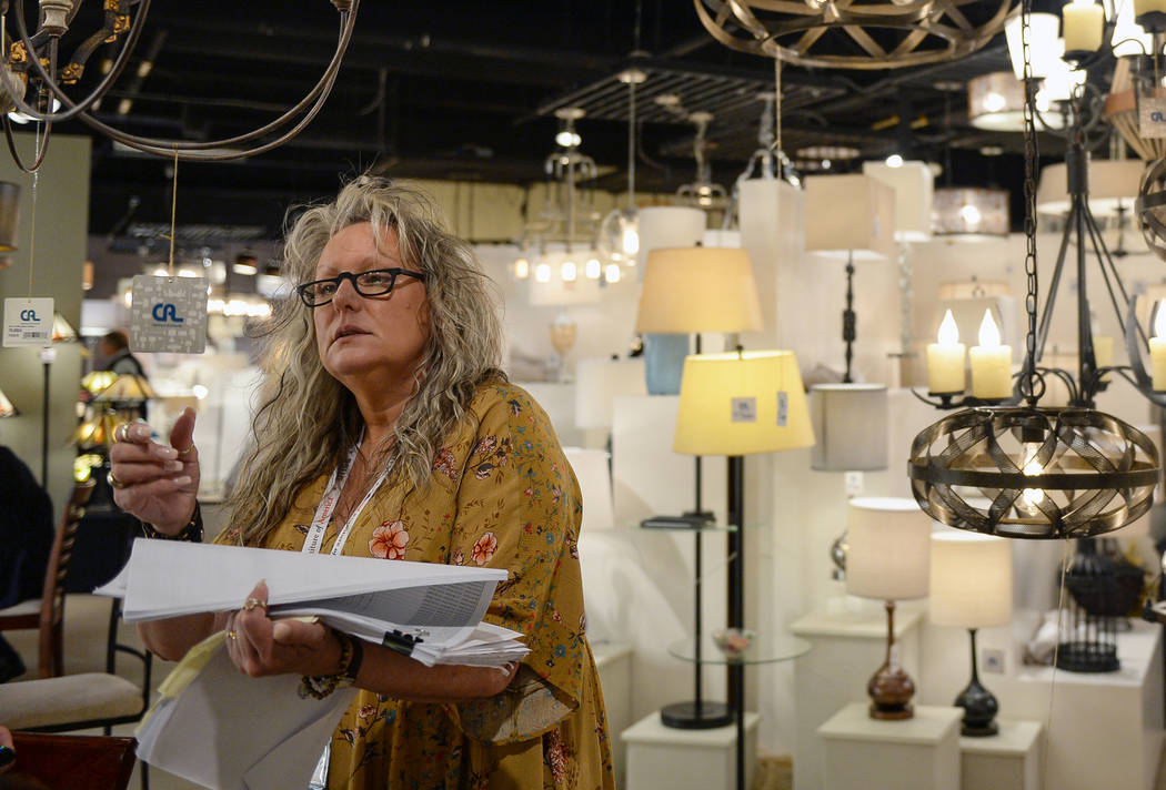Debbie Gursley looks at the lamps on display at the CA Lighting & Accessories exhibit during the second day of the Las Vegas Market held at the World Market Center in Las Vegas, Monday, Jan. 2 ...
