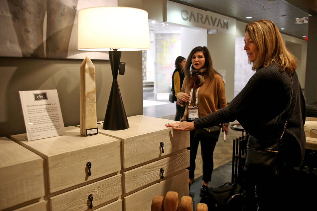 Shelley Bonelli of Los Gatos touches a solid wood cabinet with a gray wash wax on the First Look showroom tour at Las Vegas Market at the World Market Center in Las Vegas, Monday, Jan. 28, 2019. A ...