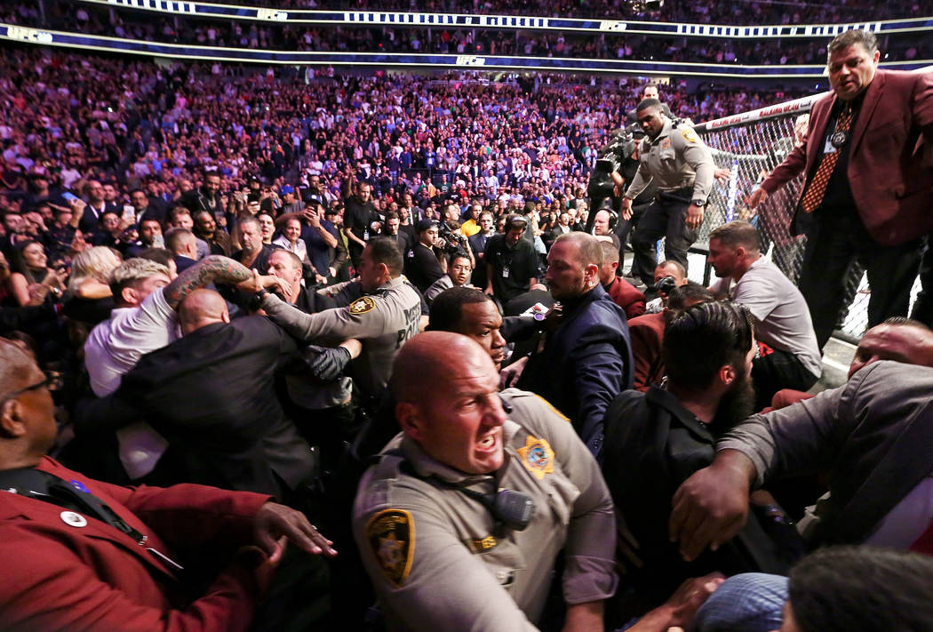 Las Vegas police and security try to stop fights that broke out after Khabib Nurmagomedov jumped out of the octagon following his win over Conor McGregor in their lightweight title bout at UFC 229 ...