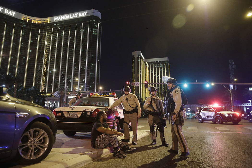 Police officers stand at the scene of a mass shooting near Mandalay Bay on the Las Vegas Strip on Oct. 1, 2017. (AP Photo/John Locher)