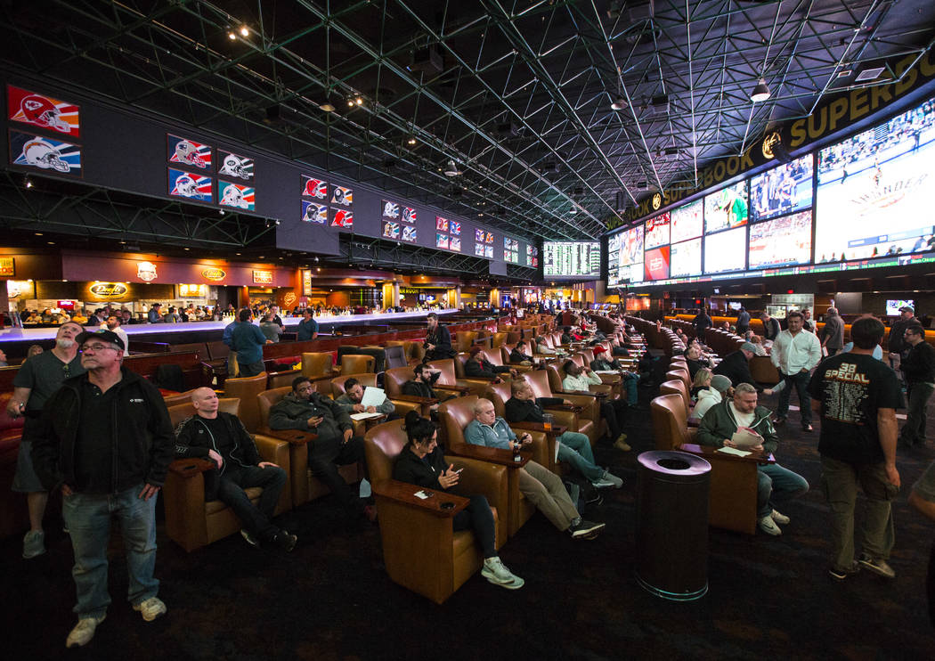 Bettors look at the displays of prop bets for the Super Bowl at the Westgate Superbook in Las Vegas on Thursday, Jan. 24, 2019. The sportsbook posted 442 two-way props and more than 1,000 betting ...