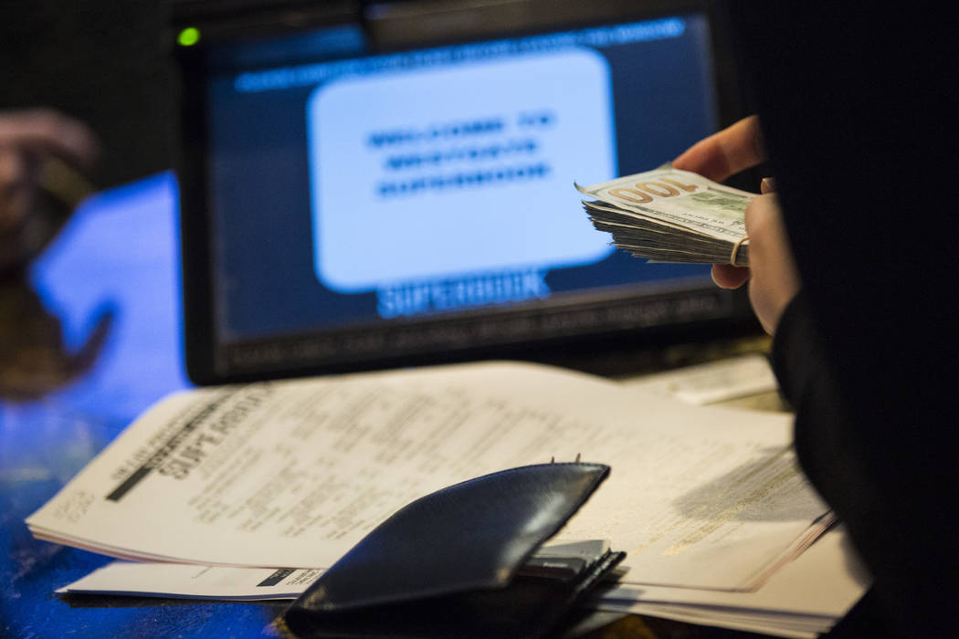 A bettor from Singapore takes out cash to place prop bets for the Super Bowl at the Westgate Superbook in Las Vegas on Thursday, Jan. 24, 2019. The sportsbook posted 442 two-way props and more tha ...