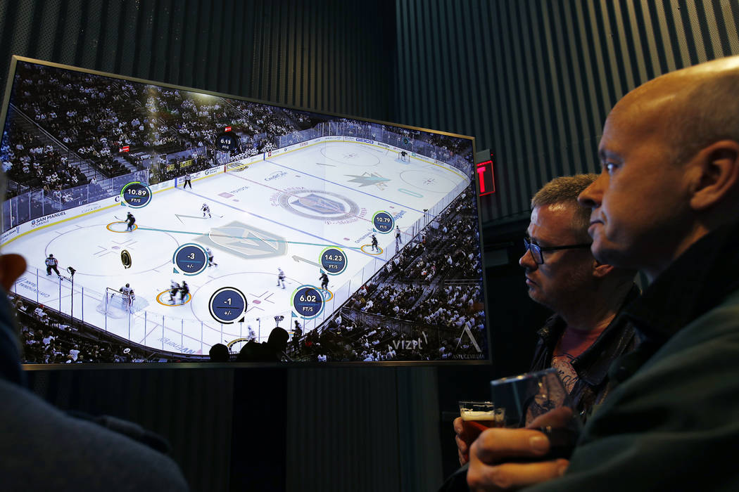 People watch real-time puck and player tracking technology on display during an NHL hockey game between the Vegas Golden Knights and the San Jose Sharks, in Las Vegas, Thursday, Jan. 10, 2019. The ...